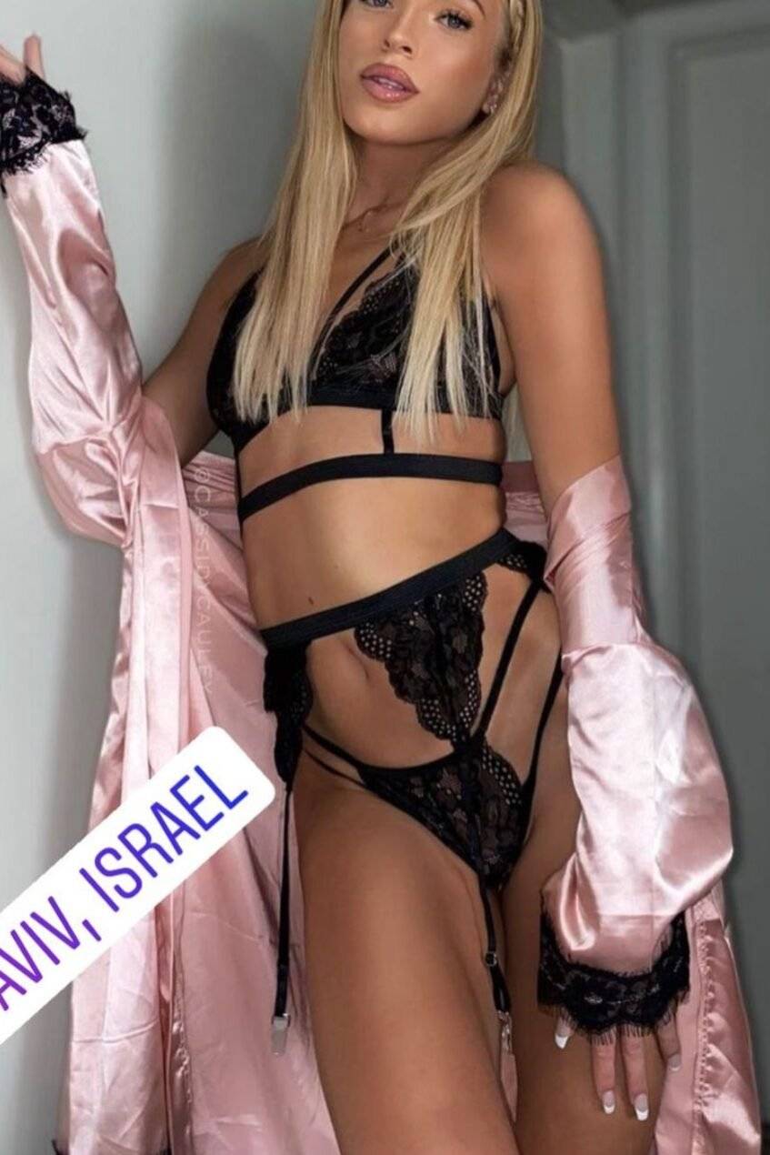 WhatsApp-Image-2022-03-03-at-19.21.29-1 אישה בלבוש תחתון שחור וחלוק ורוד, עומדת ליד דלת, מיקום בתל אביב, ישראל.