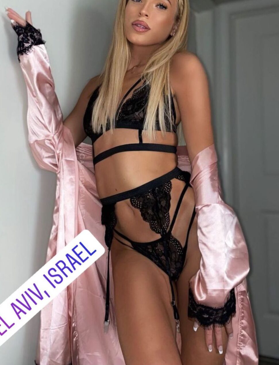 WhatsApp-Image-2022-03-03-at-19.21.29-1 אישה בלבוש תחתון שחור וחלוק ורוד, עומדת ליד דלת, מיקום בתל אביב, ישראל.