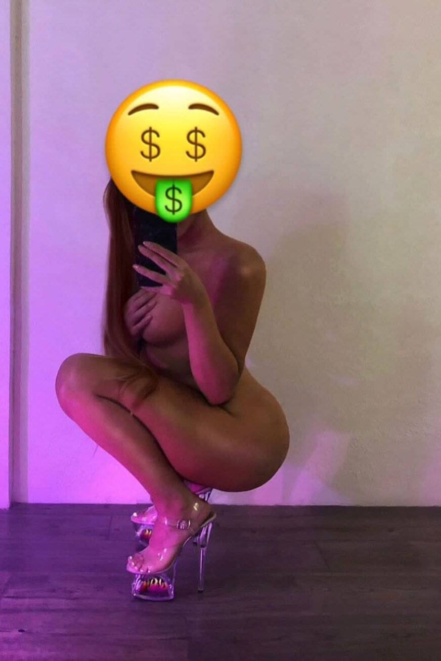 WhatsApp-Image-2022-04-14-at-14.15.38 דמות עירומה מחזיקה טלפון תוך כדי ישיבה על עקבים, פנים מכוסות באימון מוזר עם סימן דולר.
