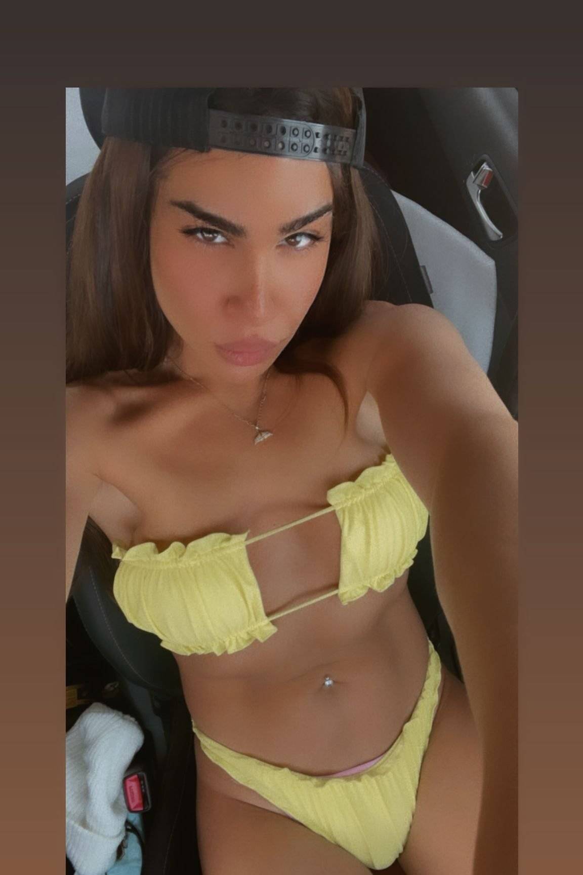 WhatsApp-Image-2022-04-27-at-13.35.16 אדם לובש בגדי ים צהובים יושב ברכב וחובש כובע מצחייה הפוך.