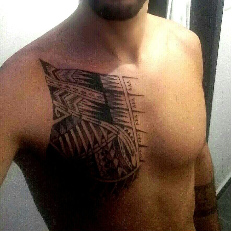 אדם ללא חולצה עם קעקוע פולינזי משורטט על החזה הימני.