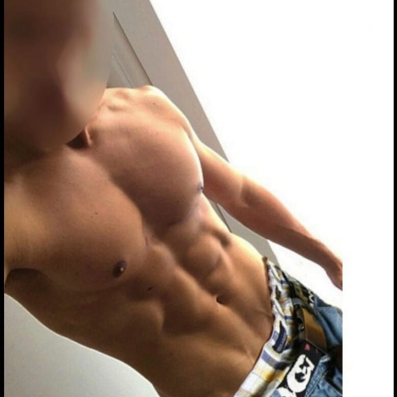 פלג גוף עליון של גבר בעל שרירים בולטים, עם פנים מטושטשות, לובש ג'ינס וחגורה.